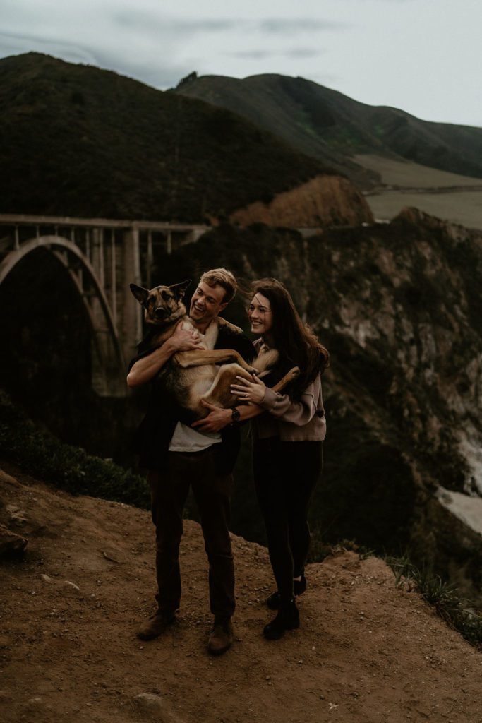 Couple holding dog for their engagement photos in BIg Sur California Engagement Photos California Coast 
