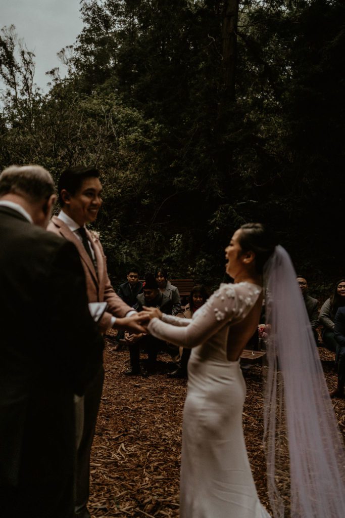 Couple laughing with the officiant with family looking on San Francisco Intimate Wedding Photography Wedding photos