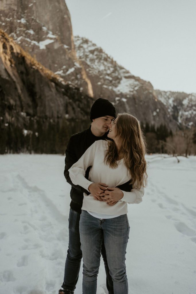Couple hugging in Yosemite Valley Winter Engagement Photos Snowy Engagement Photography Adventures in the snow 