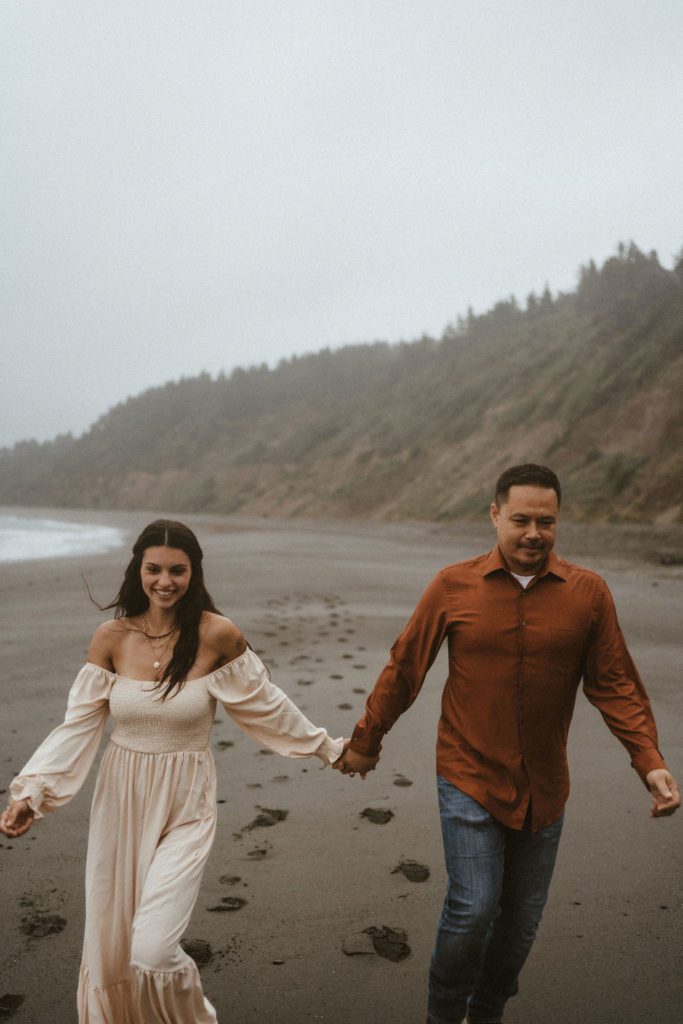 California Elopement Photographer California engagement photography Engaged Couple running on moody Northern California Beach