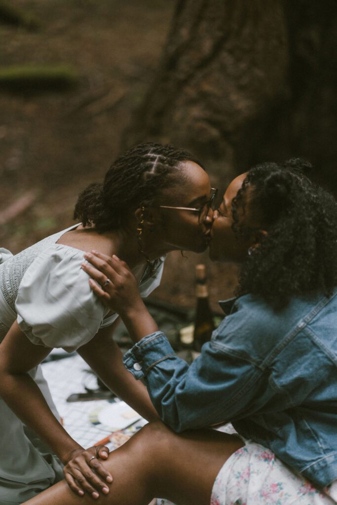 Two girls kissing and celebrating their engagement in the redwoods of Northern California. Proposal Photos in the redwoods. 